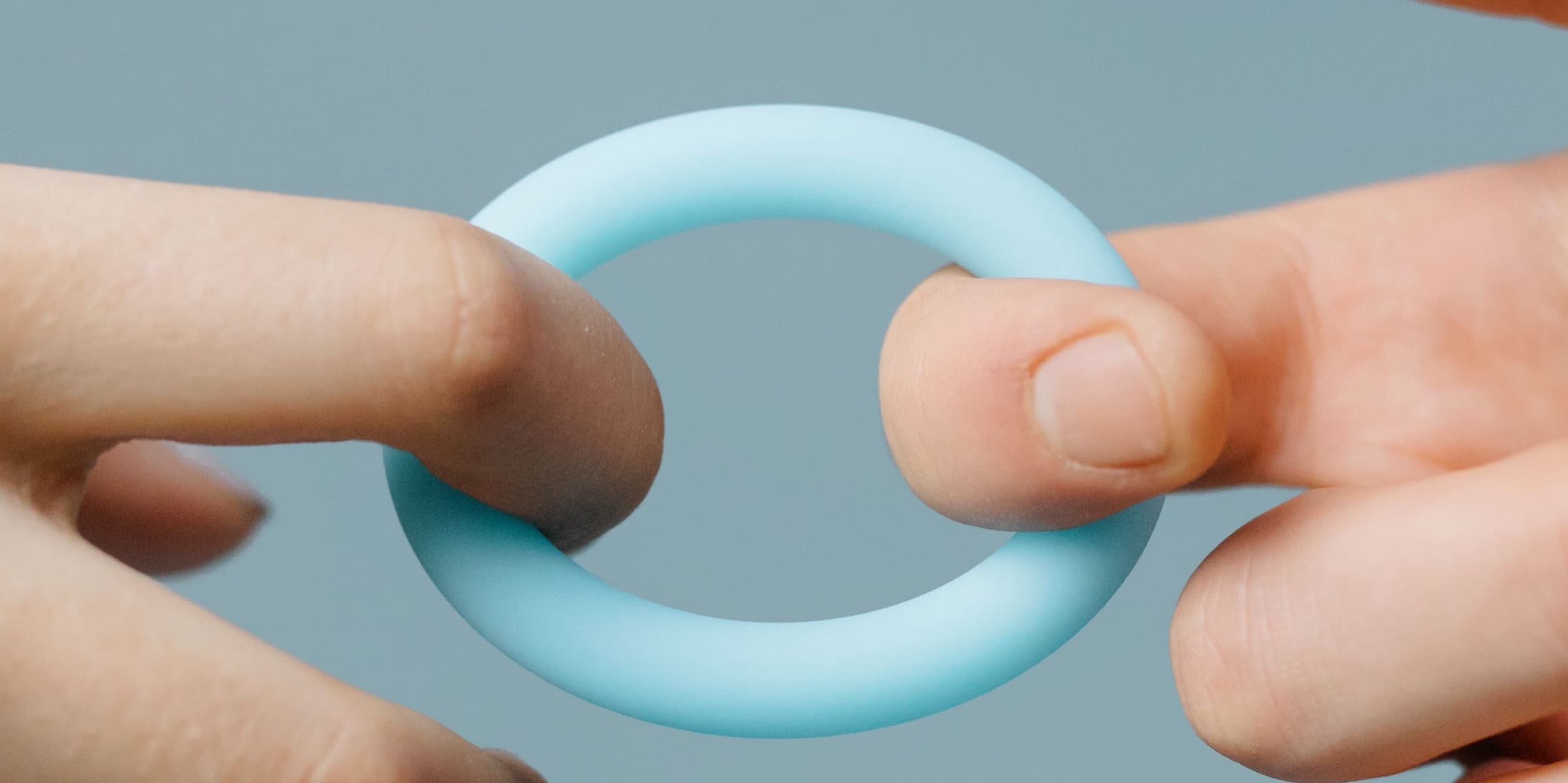 Hands holding a light blue silicone ring