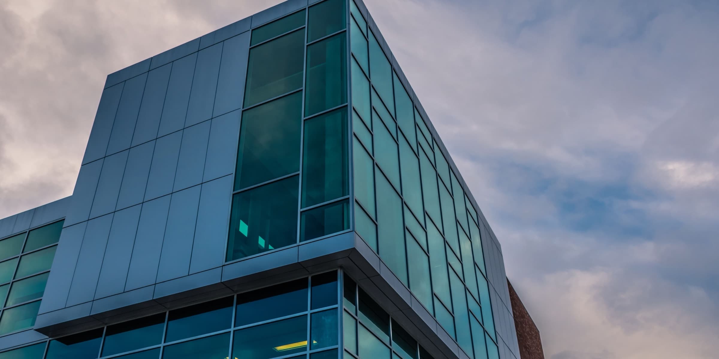 Glass curtain wall under a cloudy sky