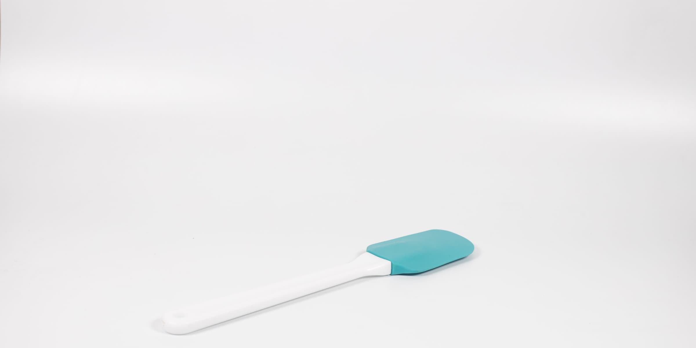 Blue and white silicone spatula on white