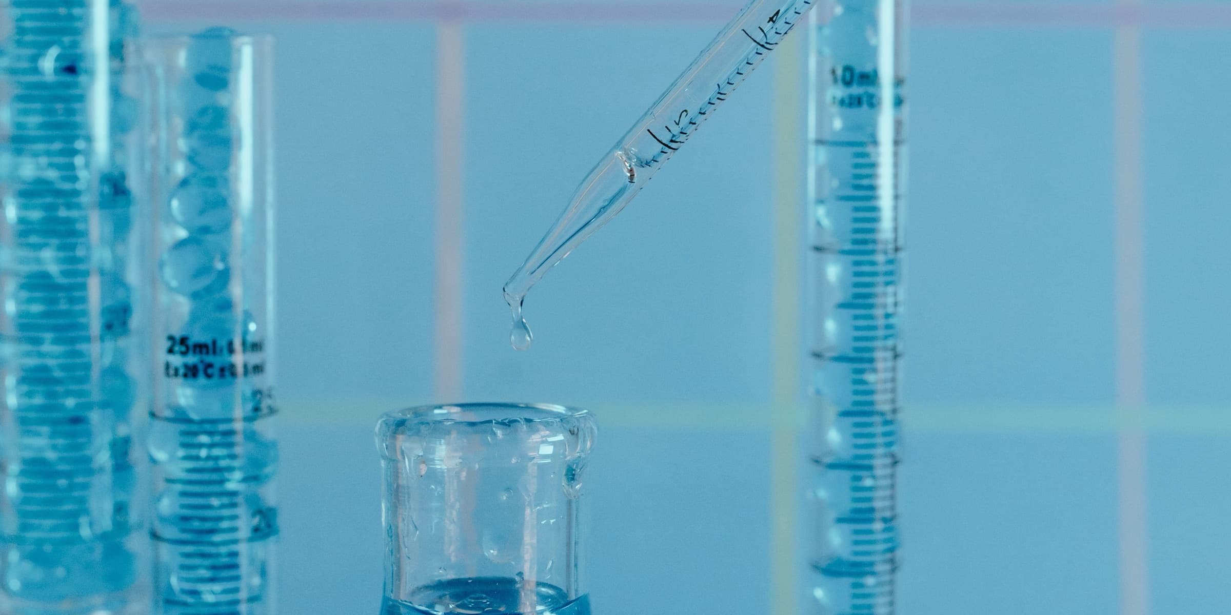 Blue-toned glassware with pipette and graduated cylinders